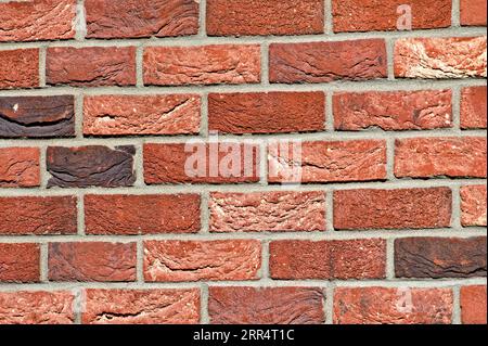 Abstract background photo of wall made of orange bricks. Lovey plastic texture facing on the building. Possible to use as pattern background. Stock Photo