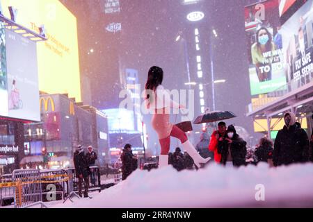 201217 -- NEW YORK, Dec. 17, 2020 -- A woman poses for a photo in snow on Times Square in New York, the United States, Dec. 16, 2020. A snow storm hit New York on Wednesday.  U.S.-NEW YORK-SNOW WangxYing PUBLICATIONxNOTxINxCHN Stock Photo