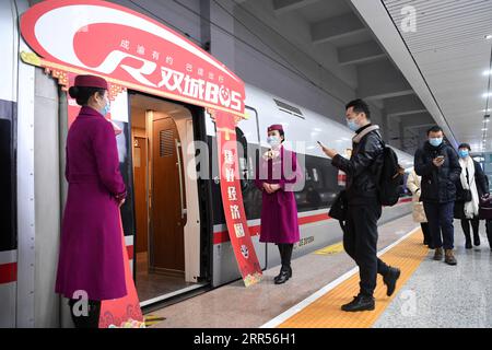 201224 -- CHONGQING, Dec. 24, 2020 -- Passengers walk to board the Fuxing high-speed train G8608 bound for Chengdu East Railway Station in southwest China s Sichuan Province, at Shapingba Railway Station in southwest China s Chongqing on Dec. 24, 2020. On Thursday morning, with G8608 and G8607 trains respectively pulling out of Chongqing Shapingba Railway Station and Chengdu East Railway Station, the Fuxing CR400AF trains plying on the railway linking Chengdu, capital of Sichuan Province, and Chongqing Municipality were officially put into operation at a speed of 350 km/h, reducing the travel Stock Photo