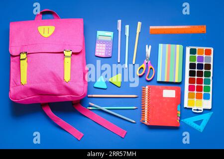 Composition with stylish school backpack and different stationery on blue background Stock Photo