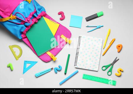 Composition with stylish school backpack and different stationery on grey background Stock Photo