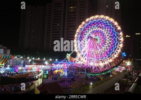 Rajkot, India. 6th September, 2023. Colorful Ferris wheel neon light illuminates attracting people during Krishna Janmashtami at 150 ft ring road in Rajkot. Credit: Nasirkhan Davi/Alamy Live News Stock Photo