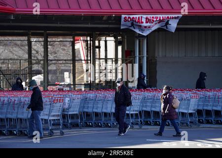 210109 -- NEW YORK, Jan. 9, 2021 -- People walk past shopping carts in New York, the United States, on Jan. 9, 2021. The total number of COVID-19 cases in the United States topped 22 million on Saturday, according to the Center for Systems Science and Engineering CSSE at Johns Hopkins University.  U.S.-NEW YORK-COVID-19-CASES-22 MILLION WangxYing PUBLICATIONxNOTxINxCHN Stock Photo