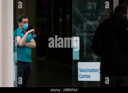 210113 -- LONDON, Jan. 13, 2021 -- A staff member wearing a face mask is seen in the Vaccination Centre at ExCel exhibition centre in London, Britain, Jan. 12, 2021. British Prime Minister Boris Johnson on Monday warned against false complacency as the country is seeking to speed up the coronavirus vaccine rollout. According to the prime minister, 2.4 million coronavirus jabs have been administered across Britain. Seven new mass vaccination sites in England opened Monday, as the country races against time to bring the pandemic under control.  BRITAIN-LONDON-COVID-19-VACCINE ROLLOUT HanxYan PUB Stock Photo