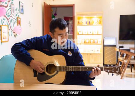 210114 -- MOHE, Jan. 14, 2021 -- Firefighter Wu Junming plays the guitar in the activity room of the fire station in Beiji Village of Mohe City, northeast China s Heilongjiang Province, Jan. 13, 2021. Firefighters stick to their post and keep training despite the freezing weather in Mohe, the northernmost city in China, where the temperature is often below minus 40 degrees Celsius in winter.  CHINA-HEILONGJIANG-MOHE-WINTER-FIRE FIGHTERSCN XiexJianfei PUBLICATIONxNOTxINxCHN Stock Photo