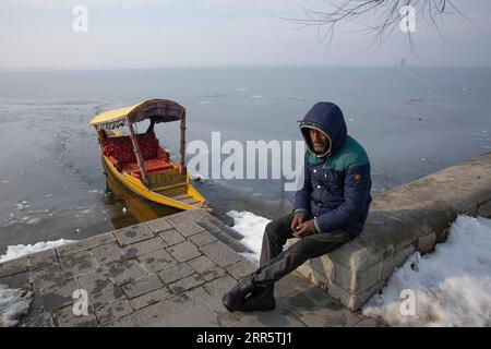 210116 -- BEIJING, Jan. 16, 2021 -- A boatman waits for customers on the banks of frozen Dal lake in Srinagar, the summer capital of Indian-controlled Kashmir, Jan. 15, 2021.  XINHUA PHOTOS OF THE DAY JavedxDar PUBLICATIONxNOTxINxCHN Stock Photo