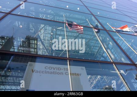 210124 -- NEW YORK, Jan. 24, 2021 -- Flags are reflected in the window of a COVID-19 vaccination center at the Jacob K. Javits Convention Center in New York, the United States, Jan. 23, 2021. The total number of confirmed COVID-19 cases in the United States topped 24.99 million, according to the data released by Johns Hopkins University on Saturday. Photo by /Xinhua U.S.-COVID-19-CONFIRMED CASES MichaelxNagle PUBLICATIONxNOTxINxCHN Stock Photo