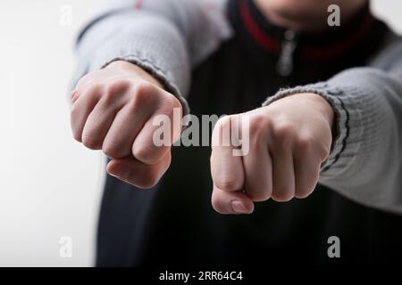 guessing game is depicted in the close-up of a young white-skinned man's hands. Wearing a gray and black sweater, he challenges you to guess which han Stock Photo