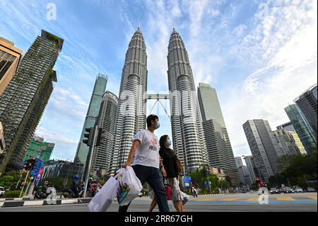 210130 -- BEIJING, Jan. 30, 2021 -- People wearing face masks walk in front of the Petronas Twin Towers in Kuala Lumpur, Malaysia, Jan. 29, 2021. Malaysia recorded 5,725 confirmed cases of COVID-19 in its highest daily spike since the outbreak of the coronavirus in the Asian country, bringing its total tally to 203,933, the Health Ministry said on Friday. Photo by /Xinhua XINHUA PHOTOS OF THE DAY ChongxVoonxChung PUBLICATIONxNOTxINxCHN Stock Photo
