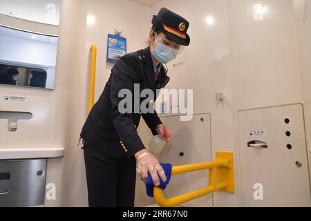 210130 -- NANCHANG, Jan. 30, 2021 -- Wang Ajing, an attendant of the China Railway Nanchang Bureau Group Co., Ltd., performs disinfection aboard a train on Jan. 26, 2021. 30-year-old Wang Ajing, who is from Xianyang City of northwest China s Shaanxi Province, is now serving as an attendant of the China Railway Nanchang Bureau Group Co., Ltd. Before she left her hometown in 2008, Wang s parents gave her a family photo, which she carried with her ever since then. Wang s mother, for some reason, was not able to attend her wedding when she got married in Jiangxi in 2013, and the mother s absence f Stock Photo