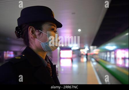 210130 -- NANCHANG, Jan. 30, 2021 -- Wang Ajing, an attendant of the China Railway Nanchang Bureau Group Co., Ltd., waits for her train to arrive at a railway station in Nanchang City, capital of east China s Jiangxi Province, Jan. 26, 2021. 30-year-old Wang Ajing, who is from Xianyang City of northwest China s Shaanxi Province, is now serving as an attendant of the China Railway Nanchang Bureau Group Co., Ltd. Before she left her hometown in 2008, Wang s parents gave her a family photo, which she carried with her ever since then. Wang s mother, for some reason, was not able to attend her wedd Stock Photo