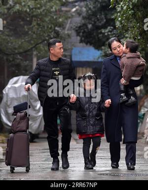210130 -- NANCHANG, Jan. 30, 2021 -- Wang Ajing, an attendant of the China Railway Nanchang Bureau Group Co., Ltd., walks with her husband and her children in Jiujiang City as they see her off to work in Nanchang City, capital of east China s Jiangxi Province, Jan. 25, 2021. 30-year-old Wang Ajing, who is from Xianyang City of northwest China s Shaanxi Province, is now serving as an attendant of the China Railway Nanchang Bureau Group Co., Ltd. Before she left her hometown in 2008, Wang s parents gave her a family photo, which she carried with her ever since then. Wang s mother, for some reaso Stock Photo