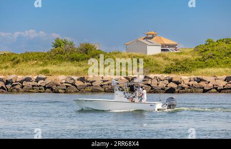 group of guys heading out of montauk on a small motorboat Stock Photo