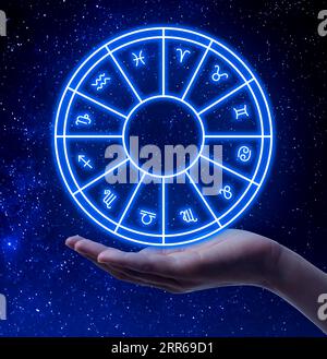Astrology. Woman with zodiac wheel against starry night sky, closeup Stock Photo