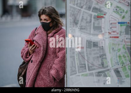 210223 -- MOSCOW, Feb. 23, 2021 -- A woman wearing a mask stands beside an information kiosk in Moscow, Russia, on Feb. 23, 2021. Russia registered 11,823 new COVID-19 cases over the past 24 hours, the lowest number of daily infections since October, bringing the nationwide tally to 4,189,153, said the official monitoring and response center on Tuesday.  RUSSIA-MOSCOW-COVID-19-CASES EvgenyxSinitsyn PUBLICATIONxNOTxINxCHN Stock Photo