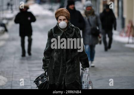 210223 -- MOSCOW, Feb. 23, 2021 -- A woman wearing a mask walks on a street in Moscow, Russia, on Feb. 23, 2021. Russia registered 11,823 new COVID-19 cases over the past 24 hours, the lowest number of daily infections since October, bringing the nationwide tally to 4,189,153, said the official monitoring and response center on Tuesday.  RUSSIA-MOSCOW-COVID-19-CASES EvgenyxSinitsyn PUBLICATIONxNOTxINxCHN Stock Photo