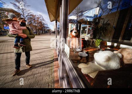 210228 -- WARSAW, Feb. 28, 2021 -- People walk past a pizza restaurant with stuffed toys seated at its empty tables in Warsaw, Poland, Feb. 27, 2021. Photo by /Xinhua POLAND-WARSAW-RESTAURANT-STUFFED TOYS JaapxArriens PUBLICATIONxNOTxINxCHN Stock Photo