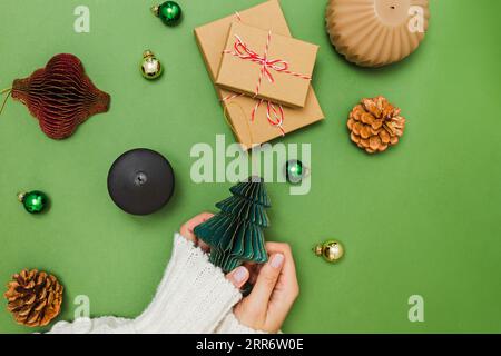 Female hands holding Christmas decor made of paper, preparing for holidays, view from the top Stock Photo