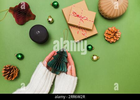 Female hands holding Christmas decor made of paper, preparing for holidays, view from the top Stock Photo