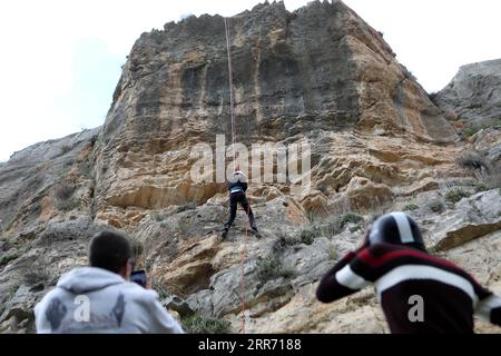 210307 -- HEBRON, March 7, 2021 -- A Palestinian woman rappels down a steep cliff in Wadi al-Qaf Nature Reserve in the West Bank city of Hebron, March 5, 2021. Contrary to what is common in their society, a group of young Palestinian women take part in rappelling from the dangerous cliffs in the West Bank. Photo by /Xinhua TO GO WITH Feature: Young Palestinian women refreshed in rappelling in West Bank MIDEAST-HEBRON-PALESTINIAN WOMEN-RAPPELLING MamounxWazwaz PUBLICATIONxNOTxINxCHN Stock Photo