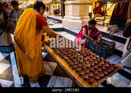 Vrindavan, Uttar Pradesh, October 19th 2019: In evening time, women, preparing clay lamps for worshipping Lord Krishna at Sri Krishna-Balaram temple Stock Photo