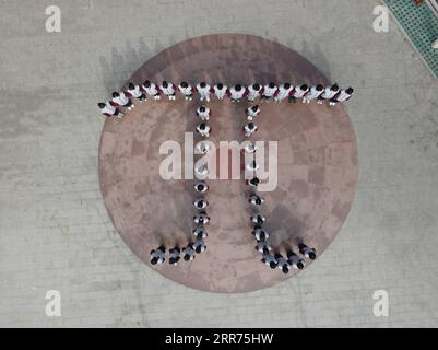 210313 -- BAODING, March 13, 2021 -- Aerial photo taken on March 13, 2021 shows students of the Zu Chongzhi High School standing in a formation of the Greek letter Pi during an event commemorating Zu Chongzhi ahead of Pi Day in Laishui County, north China s Hebei Province. March 14 is celebrated around the world as Pi Day, since 3, 1, and 4 are the first three significant digits of the mathematical constant which denotes the ratio of a circle s circumference to its diameter. Zu Chongzhi, a Chinese mathematician and astronomer from the 5th century, had made a remarkable achievement by determini Stock Photo