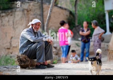 210316 -- TAIYUAN, March 16, 2021 -- File photo taken on Aug. 10, 2014 shows Liu Qingji resting at Shijiamao Village of in Yukou Town of Fangshan County, north China s Shanxi Province. Shijiamao is a small village located in rugged mountainous areas with little rainfall. Like other villagers here, Liu Qingji, an 85-year-old farmer, used to do farming at the mercy of the elements. Having dwelled many years in a gloomy yaodong , a house built into the hardened earth common across the Loess Plateau in northern China, Liu hoped to improve the living conditions and have access to fresh water some d Stock Photo