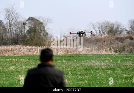 210317 -- BEIJING, March 17, 2021 -- A farmer uses a drone to spray pesticide in the fields in Huagang Town, Feixi County of Hefei, east China s Anhui Province, Feb. 23, 2021.  Xinhua Headlines: China s spring farming goes high-tech to ensure food security LiuxJunxi PUBLICATIONxNOTxINxCHN Stock Photo