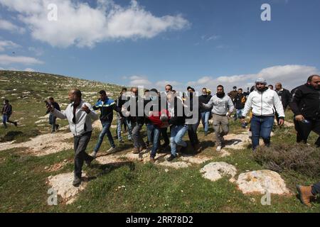 210319 -- NABLUS, March 19, 2021 -- Palestinian protesters carry an injured man after he was shot in the head during clashes with Israeli soldiers following a protest against the expansion of Jewish settlements in the West Bank village of Beit Dajan, east of Nablus, March 19, 2021. Photo by /Xinhua MIDEAST-NABLUS-PROTEST NidalxEshtayeh PUBLICATIONxNOTxINxCHN Stock Photo