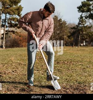 Man using shovel dig hole planting tree Stock Photo