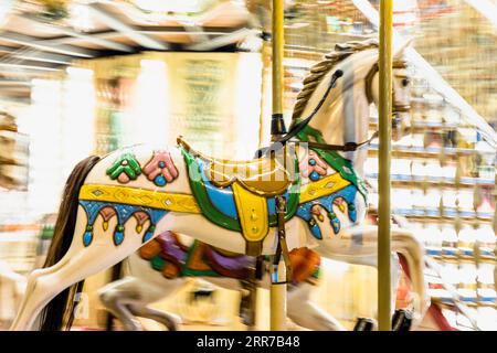 Nostalgic horse detail carousel spinning with light blurs night Stock Photo