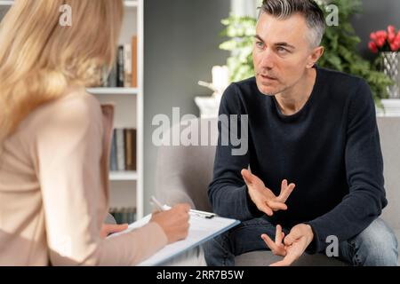 Mid shot man talking therapist Stock Photo