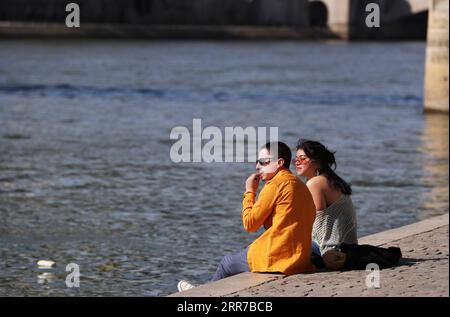 210324 -- PARIS, March 24, 2021 -- A couple enjoy sunshine at the Seine River banks in Paris, France, March 24, 2021. A total of 14,678 new cases were recorded over the past 24 hours, bringing the total infections in the country to more than 4.3 million. As of Tuesday evening, 26,756 patients were hospitalized for COVID-19 infection in France, including 4,634 in intensive care, according to the health authorities.  FRANCE-PARIS-COVID-19 GaoxJing PUBLICATIONxNOTxINxCHN Stock Photo