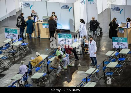210324 -- PARIS, March 24, 2021 -- People wait in a COVID-19 vaccination center at the National Velodrome de Saint-Quentin-en-Yvelines in Saint-Quentin-en-Yvelines, France, on March 24, 2021. French President Emmanuel Macron on Tuesday stressed the importance of vaccination as the country s COVID-19 cases kept rising. Since the start of the vaccination campaign in France, nearly 6.6 million people, or about 12.6 percent of the adult population, have received at least one injection, and over 2.5 million have received two injections, according to the Health Ministry. Photo by /Xinhua FRANCE-SAIN Stock Photo