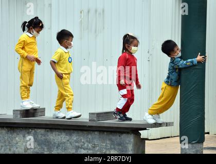 210326 -- HONG KONG, March 26, 2021 -- Children wearing face masks play outside in Hong Kong, south China, March 26, 2021. Hong Kong s Center for Health Protection CHP reported 11 additional confirmed cases of COVID-19 on Friday, taking the total tally to 11,439.  CHINA-HONG KONG-COVID-19-CASES CN LoxPingxFai PUBLICATIONxNOTxINxCHN Stock Photo