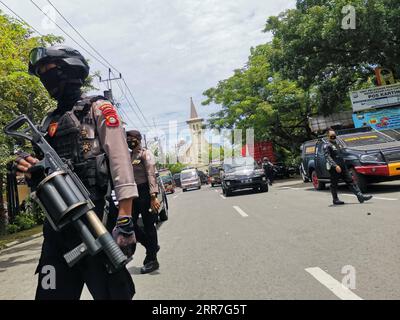 News Bilder des Tages 210328 -- MAKASSAR, March 28, 2021 -- Indonesian police officers stand guard near a Cathedral church in Makassar, South Sulawesi, Indonesia, March 28, 2021. The Indonesian police have suspected that two people committed a suicide bombing outside the Cathedral in the port city of Makassar, capital of South Sulawesi province in east Indonesia on Sunday morning, injuring at least 14 people. Photo by /Xinhua INDONESIA-MAKASSAR-CHURCH-BOMB MasyudixF PUBLICATIONxNOTxINxCHN Stock Photo