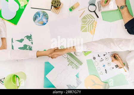 High angle view two businesspeople shaking hands desk Stock Photo