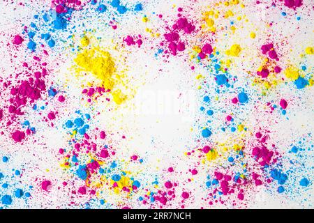Splatter yellow pink blue holi color powder white background Stock Photo