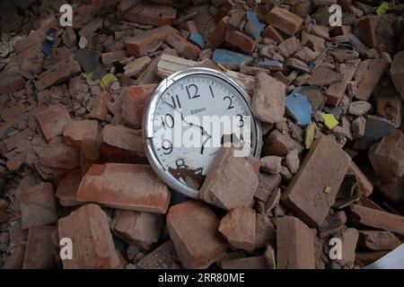 210411 -- EAST JAVA, April 11, 2021 -- A wall clock is seen near damaged houses after a 6.1 magnitude quake hit Majang Tengah village in Malang, East Java, Indonesia, April 11, 2021. Six people were killed, another one was seriously injured, and scores of buildings were damaged after a 6.1-magnitude quake rocked Indonesia s western province of East Java on Saturday, officials said. The earthquake struck at 2 p.m. Jakarta time 0700 GMT with the epicenter 96 km south of Kepanjen town of Malang district with a depth of 80 km, Andry Sembiring, an official at the Meteorology, Climatology and Geophy Stock Photo