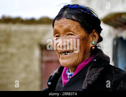 210411 -- XIGAZE, April 11, 2021 -- Lhapa poses for a photo in Puga Village of Xigaze, southwest China s Tibet Autonomous Region, March 20, 2021. Lhapa, born in 1945, is a villager in Puga Village. When she was a child, her mother became blind due to overwork and lost the ability to work. The serf owner drove her out of the manor, and Lhapa s mother had to beg everywhere with her sister for a living. In 1959, during the democratic reform in Tibet, the Lhapa s family were finally reunited and alloted 24 mu about 1.6 hectare of land, six sheep and two cows. They also built a house belonging to t Stock Photo