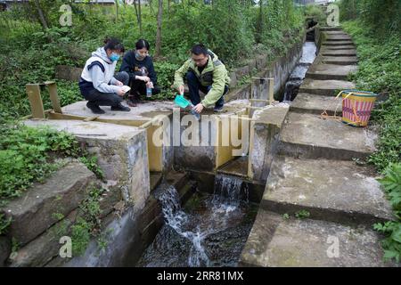 210412 -- ZHONGXIAN, April 12, 2021 -- Researchers collect water samples at a sampling point in Zhongxian County, southwest China s Chongqing, April 11, 2021. The Three Gorges project is a vast multi-functional water-control system on the Yangtze River, China s longest waterway, with a 2,309-meter-long and 185-meter-high dam. The water levels of the reservoir area inevitably fluctuate on an annual discharge-storage cycle between 145m to 175m at the dam. The water level fluctuation zone also encounters some eco-environmental problems, including soil erosion and non-point source pollution. Resea Stock Photo