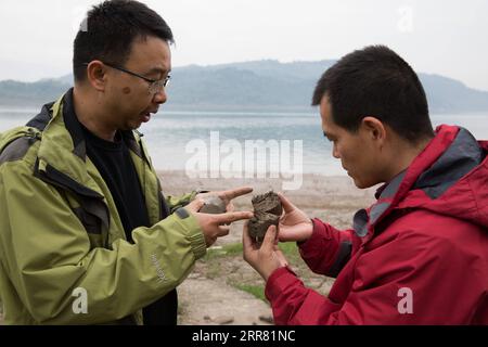 210412 -- ZHONGXIAN, April 12, 2021 -- Researchers discuss the characteristic of sediments at water level fluctuation zone of the Three Gorges Reservoir in Zhongxian County, southwest China s Chongqing, April 10, 2021. The Three Gorges project is a vast multi-functional water-control system on the Yangtze River, China s longest waterway, with a 2,309-meter-long and 185-meter-high dam. The water levels of the reservoir area inevitably fluctuate on an annual discharge-storage cycle between 145m to 175m at the dam. The water level fluctuation zone also encounters some eco-environmental problems, Stock Photo