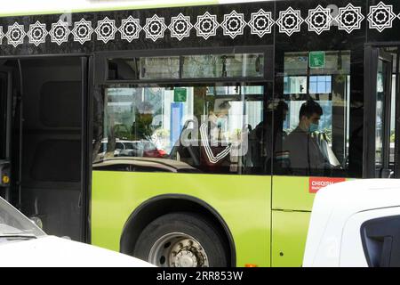 210418 -- TASHKENT, April 18, 2021 -- People wearing face masks take a bus in Tashkent, Uzbekistan, April 18, 2021. Uzbekistan introduces new restrictions on public events, catering and transport services starting from April 18 amid surging COVID-19 infections. According to the country s special commission on combating COVID-19, cafes, restaurants and public transport must use only 50 percent of their seating capacity, and the same rules apply to public meetings, as well as any scheduled international conferences and other events. Photo by /Xinhua UZBEKISTAN-TASHKENT-COVID-19 ZafarxKhalilov PU Stock Photo