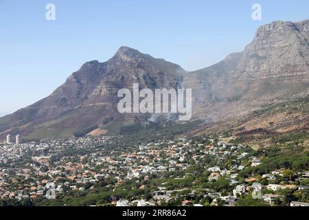 210420 -- CAPE TOWN, April 20, 2021 -- Smoke rises from Table Mountain near Vredehoek, Cape Town, South Africa, on April 20, 2021. The wildfire that broke out on South Africa s iconic Table Mountain on Sunday morning has been largely contained but the danger remains, the Western Cape provincial government said in a statement Tuesday.  SOUTH AFRICA-CAPE TOWN-TABLE MOUNTAIN-WILDFIRE LyuxTianran PUBLICATIONxNOTxINxCHN Stock Photo