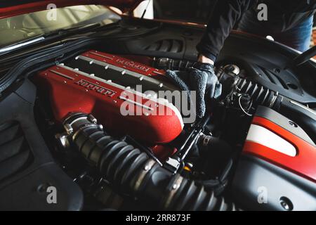 17.05.2023. Warsaw, Poland. cleaning car engine with a microfiber cloth, auto repair shop. High quality photo Stock Photo