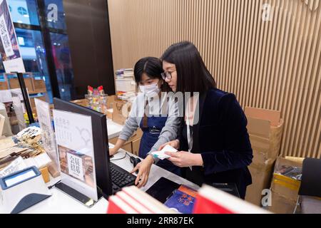 210423 -- HARBIN, April 23, 2021 -- Yu Bing R talks with a front desk employee at M.I. Bookstore in Harbin, northeast China s Heilongjiang Province, April 22, 2021. For Harbin-based bookstore manager Yu Bing, the issue of concern has always been how to create an encouraging reading environment. Born and raised in Harbin, Yu is now a veteran with 10 years experience in the bookselling trade. Yu says the biggest value of her profession is the creation of an effective platform for the sharing of good books -- How to create an enticing layout that attracts potential customers And how to pick from Stock Photo