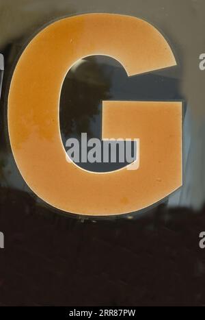 Old worn letter G, showing its age, pattern, lines and boldly grabbing attention.  Be noticed with this single letter, Stock Photo