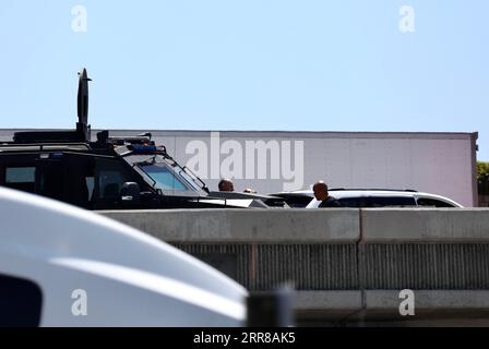 210428 -- LOS ANGELES, April 28, 2021  -- Police officers investigate at the scene where the gunman was killed in Fullerton shootout in Los Angeles, California, the United States, April 27, 2021. A gunman, suspected of killing two and wounding another in a series of drive-by shooting incidents in Los Angeles, was killed by police Tuesday morning after about five hours chase and exchange of fire. According to Raul Jovel, an officer from the Los Angeles Police Department LAPD s Media Relations Division, the shooter s rampage occurred from 0:55 a.m. to 1:25 a.m. local time, when he drove a white Stock Photo