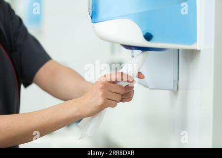 hands pulling paper towel from a dispenser Stock Photo