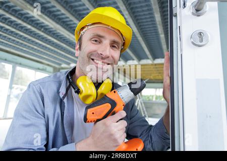 mature male builder using a cordless screwdriver Stock Photo